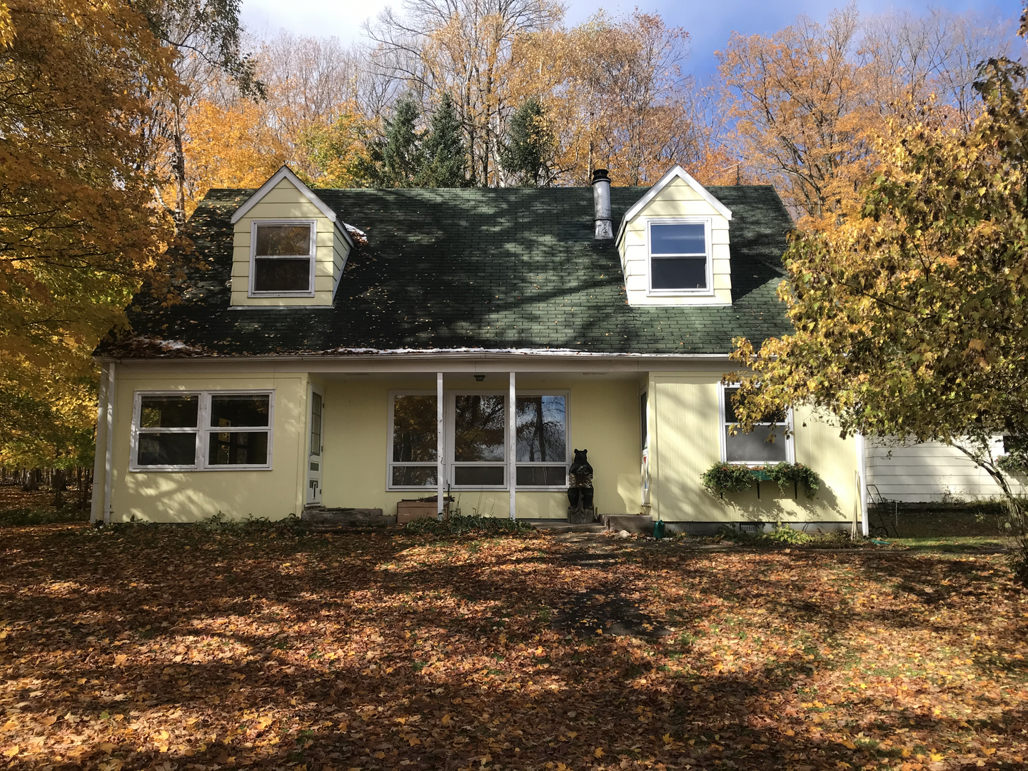 Yellow guest house with green trim on Lake Namakagon before demolition