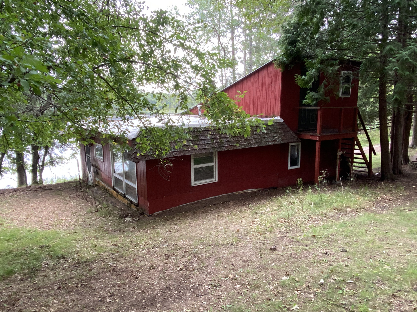 Red lakeside cabin before demolition