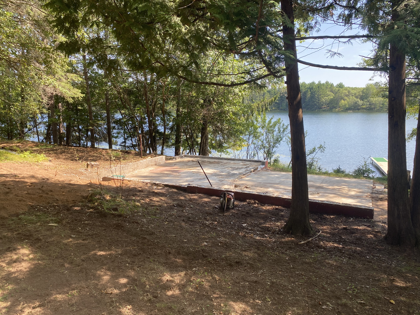 Cleared foundation slab after cabin demolition on lakeside lot