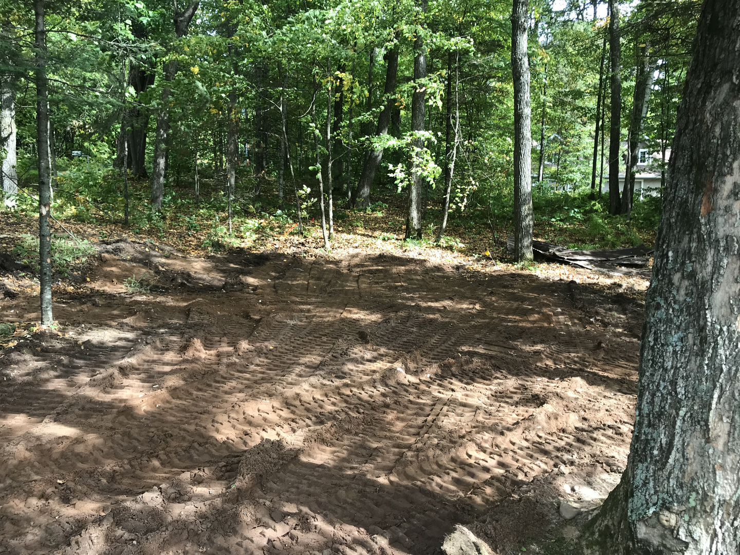 Graded lot with tire tracks after demolition and site clearing