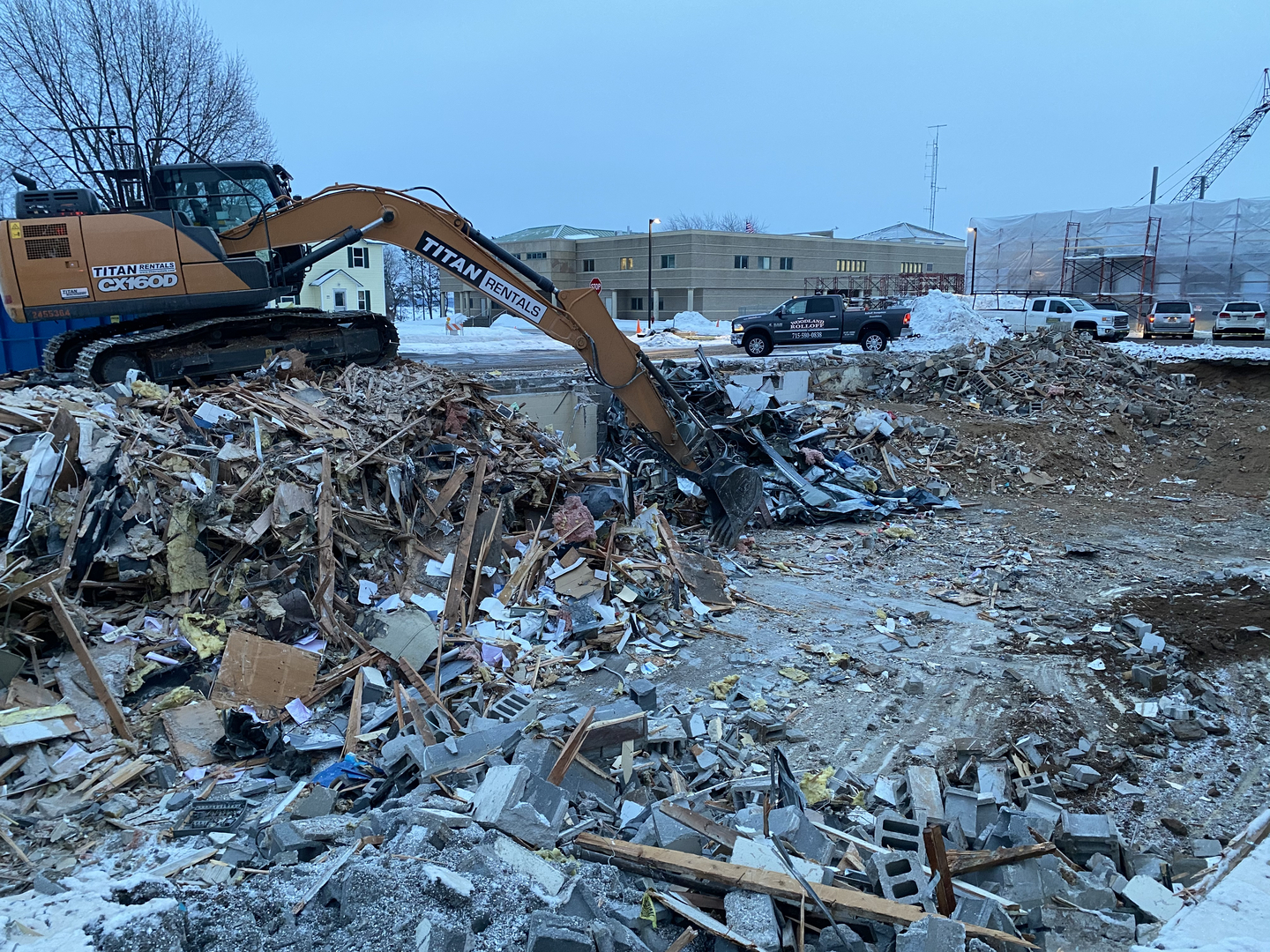 Excavator demolishing a building on a Woodland Rolloff job site