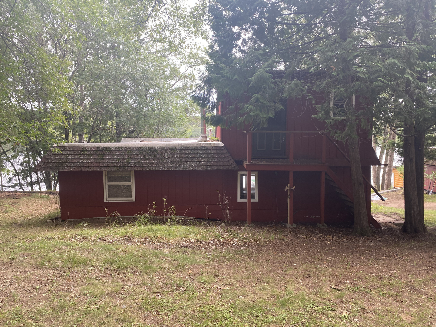 Red two-story lakeside cabin before demolition in Minong WI