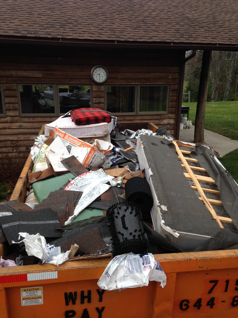 Dumpster full of cleanout debris at log cabin