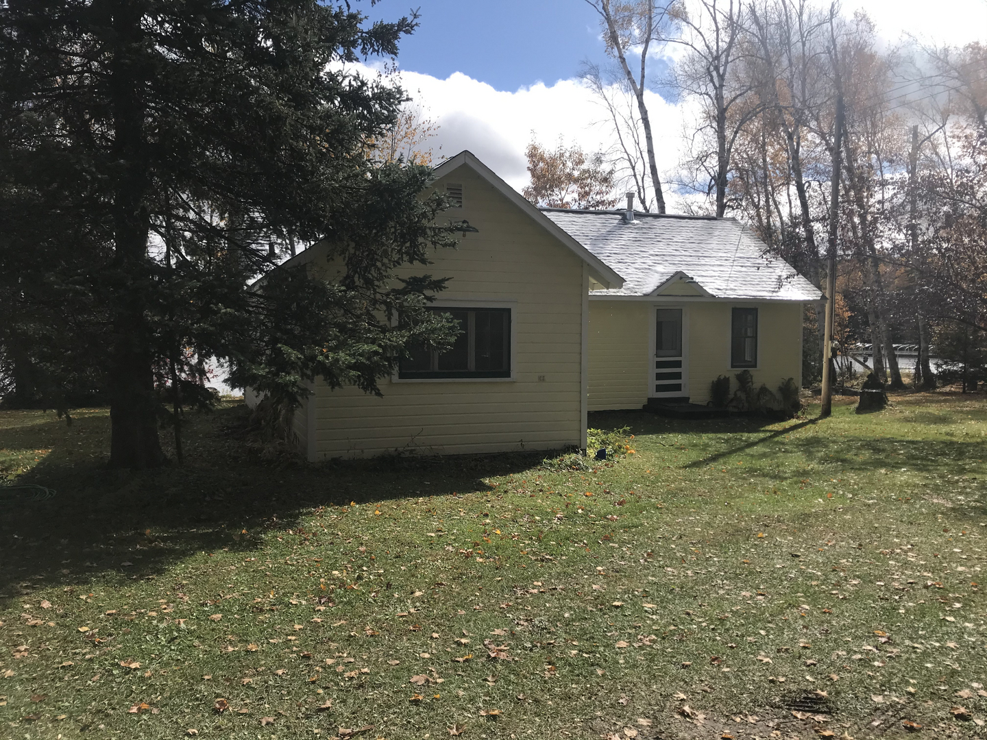 White lakeside cabin before demolition