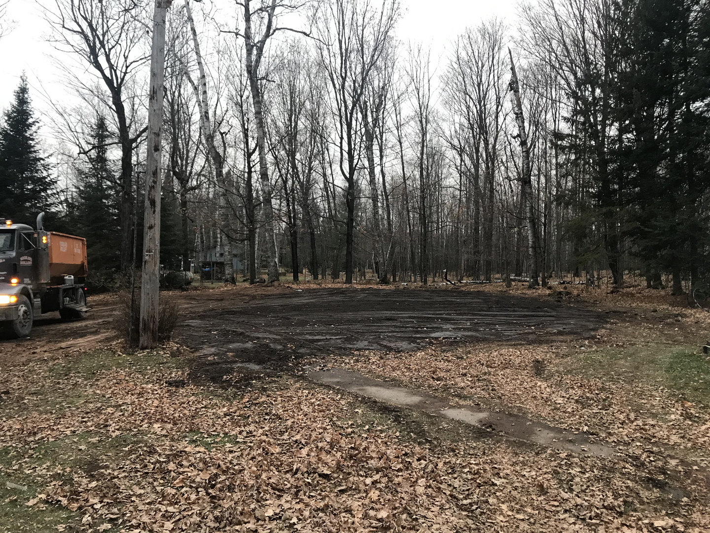 Woodland Rolloff dump truck at cleared Lake Namakagon lot after demolition
