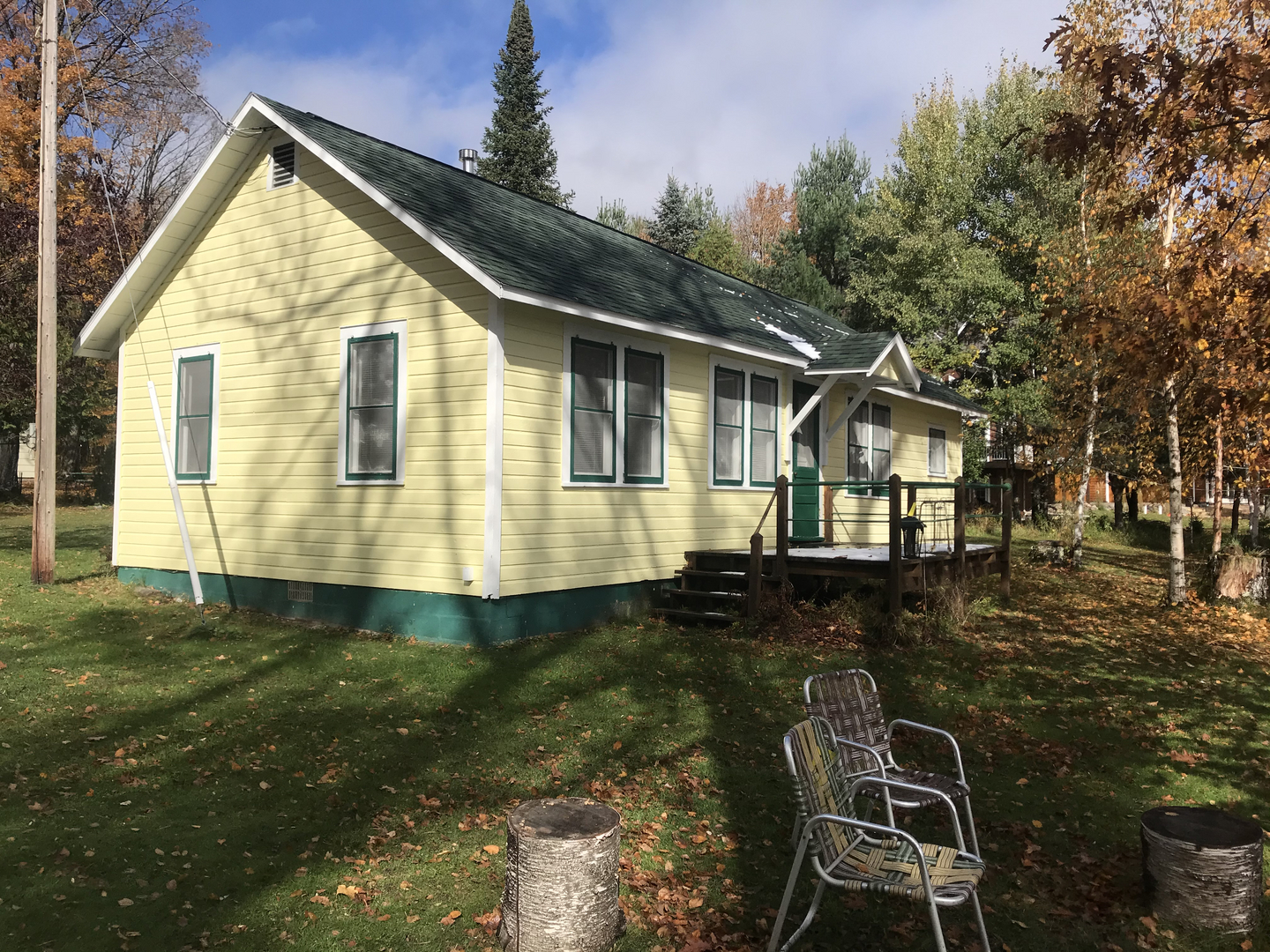 Yellow main house rear view with snow on roof before demolition