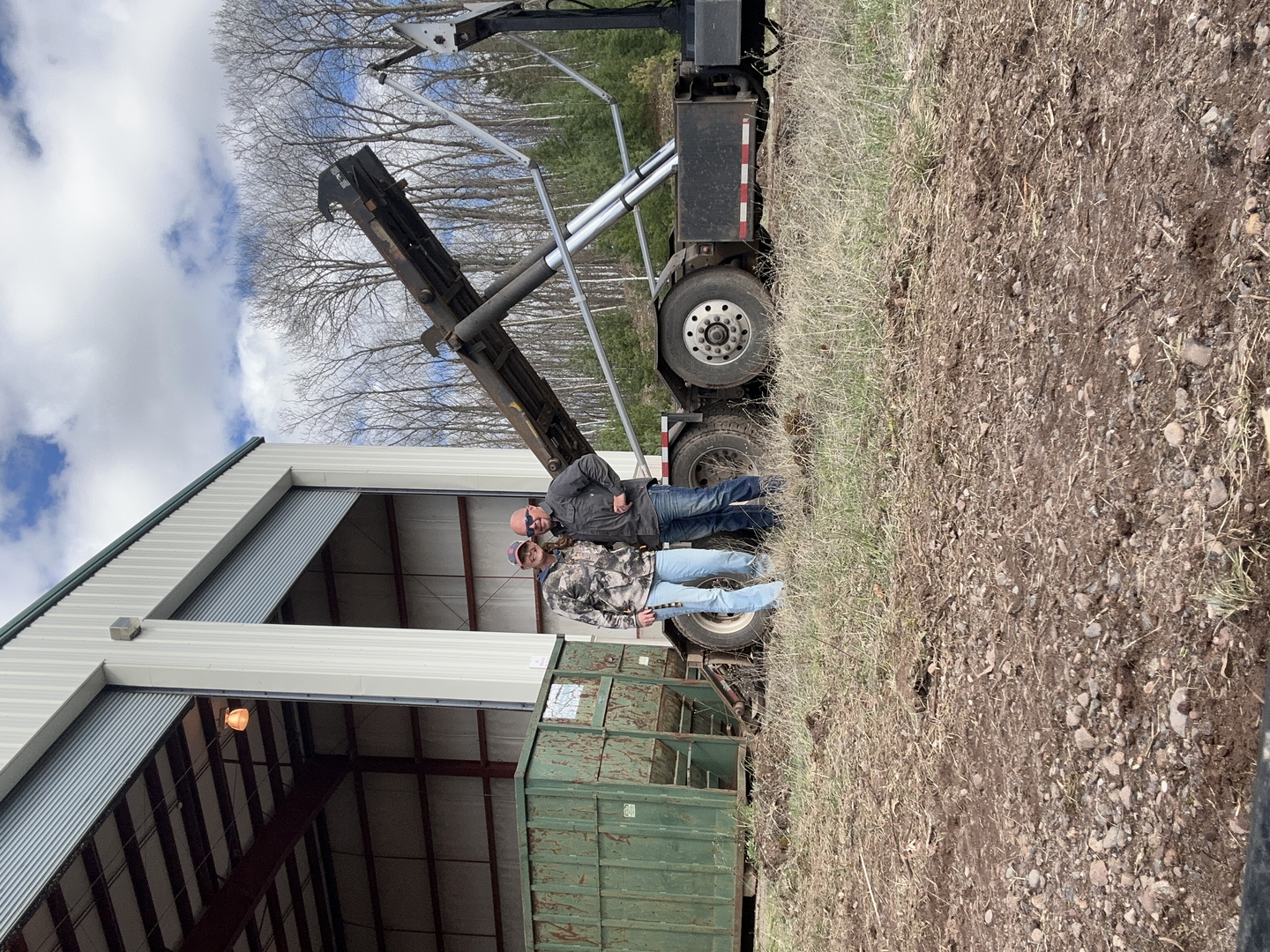 Travis and Krista standing in front of the transfer station building