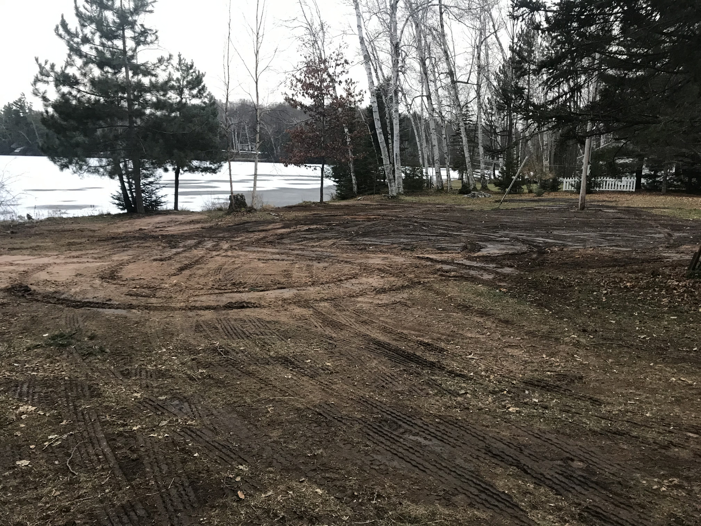 Cleared lakeside lot with tire tracks after demolition on Lake Namakagon