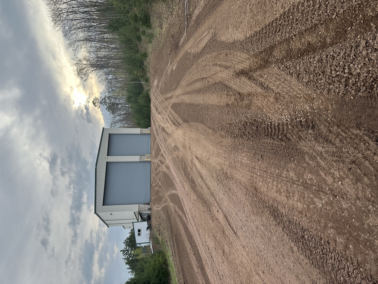 Transfer station building with graded dirt lot and two garage doors