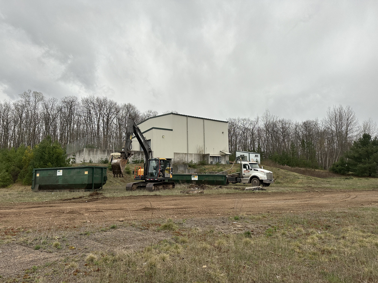 Volvo excavator and Woodland Rolloff truck at transfer station site